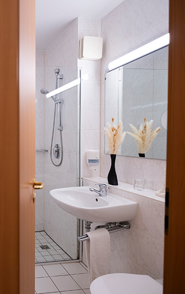 Badezimmer mit Dusche und Waschbecken